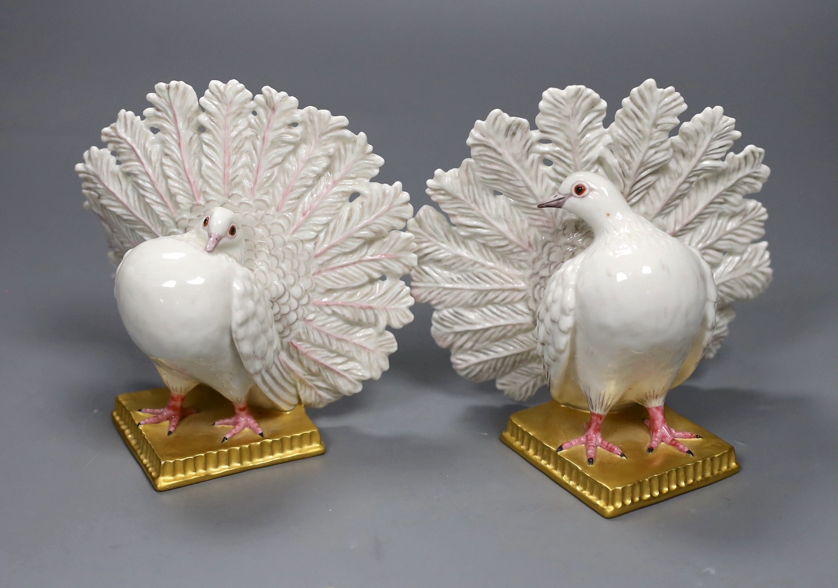 A pair of Nymphenberg porcelain figures of peacock tailed doves, 13cm tall